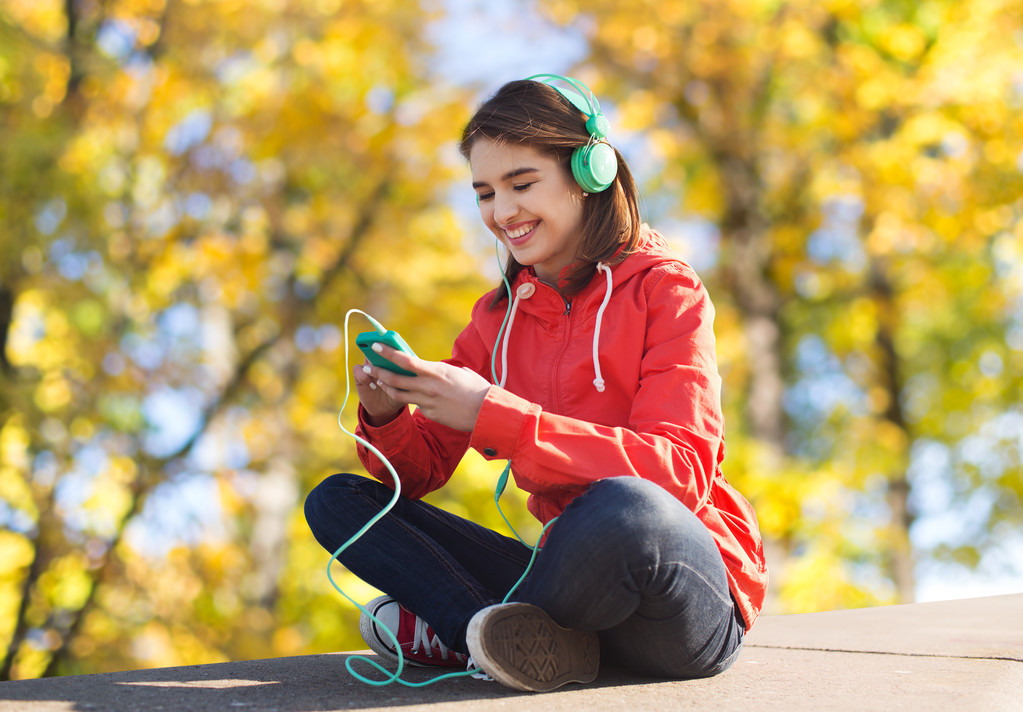 ευτυχισμένος νεαρή γυναίκα με το smartphone και ακουστικά - Φωτογραφία, εικόνα