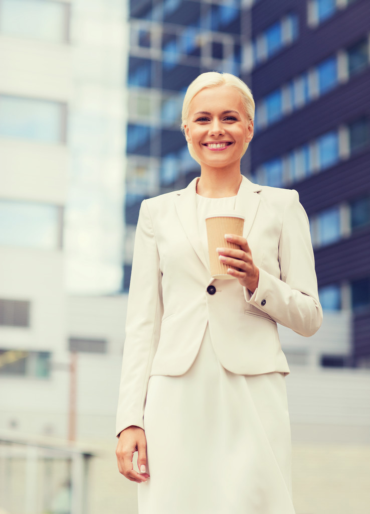femme d'affaires souriante avec tasse en papier à l'extérieur
 - Photo, image