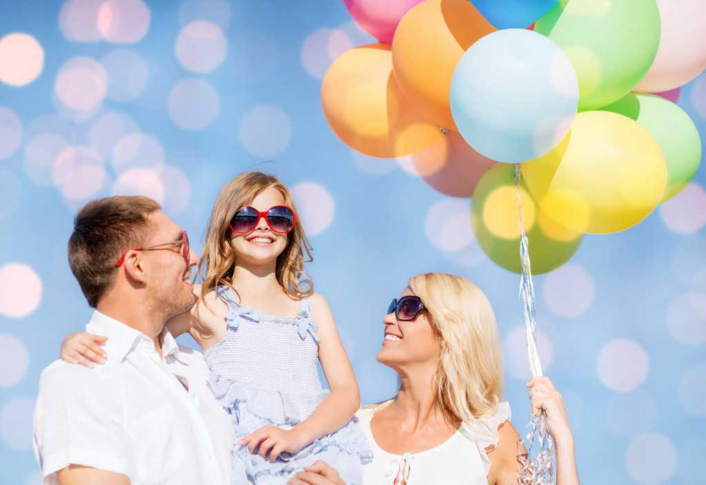 gelukkige familie met ballonnen over blauwe lichten - Foto, afbeelding