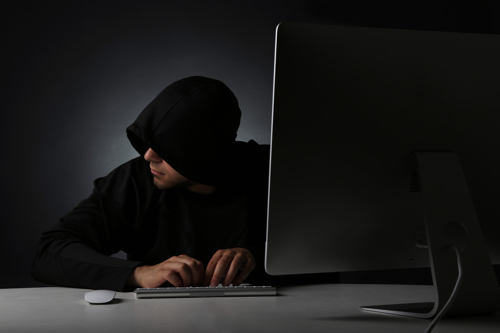 Hacker with computer on dark background - Photo, Image