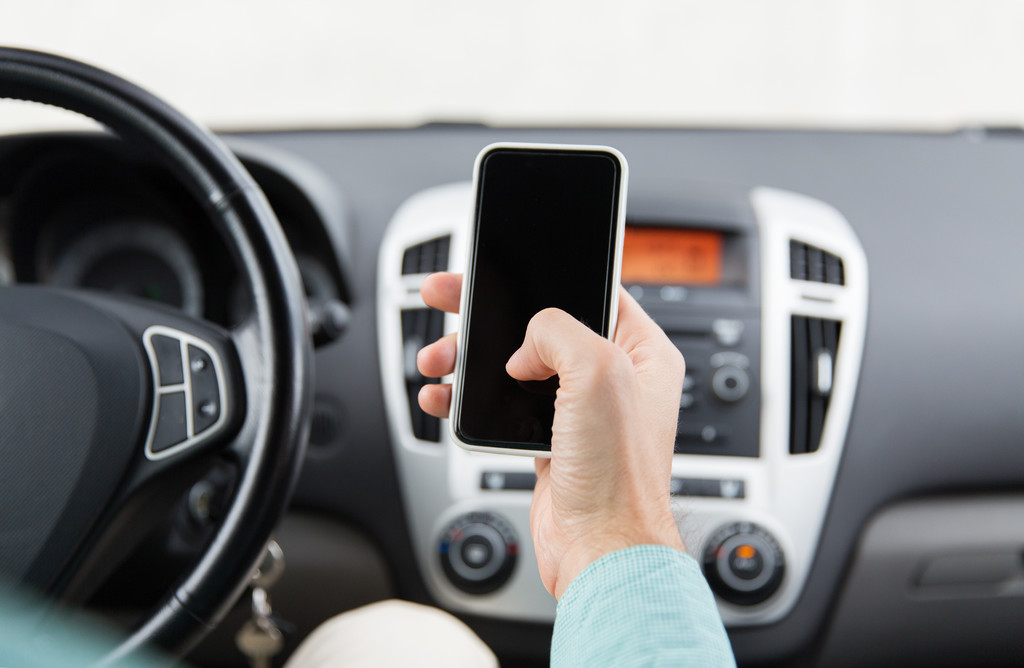 man hand with smartphone driving car - Photo, Image