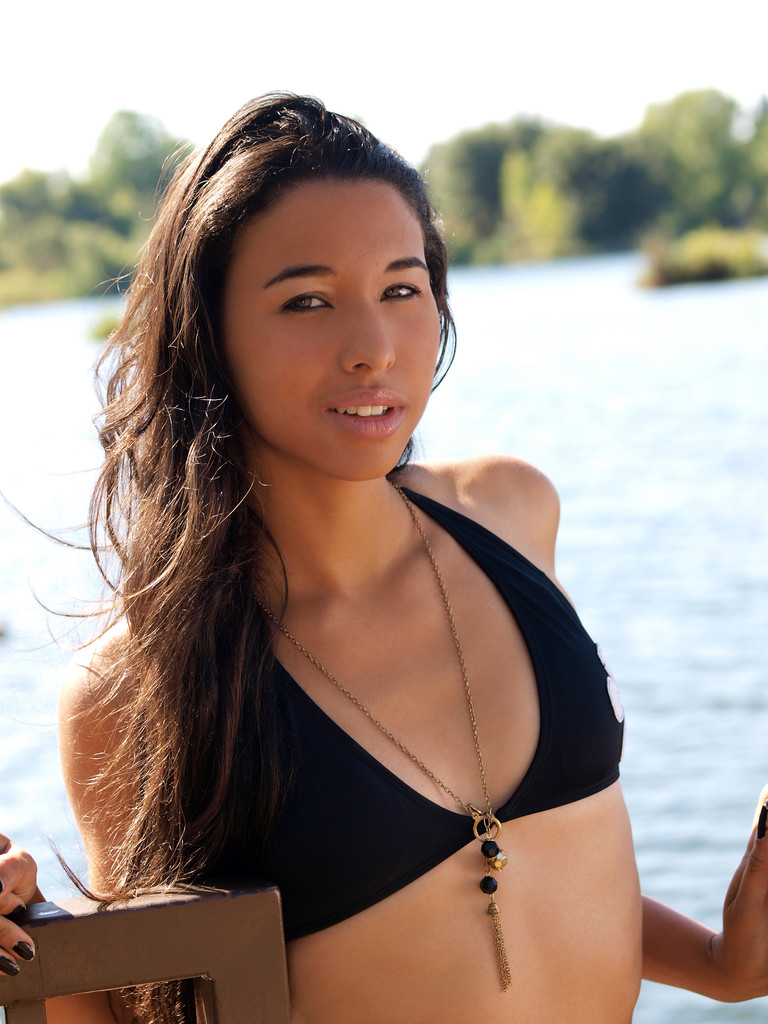 若いヒスパニック系女性黒ビキニ トップ川 - 写真・画像