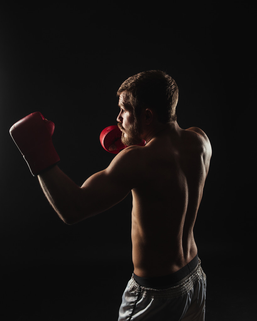 Boxeador atlético barbudo con guantes sobre fondo oscuro
 - Foto, imagen
