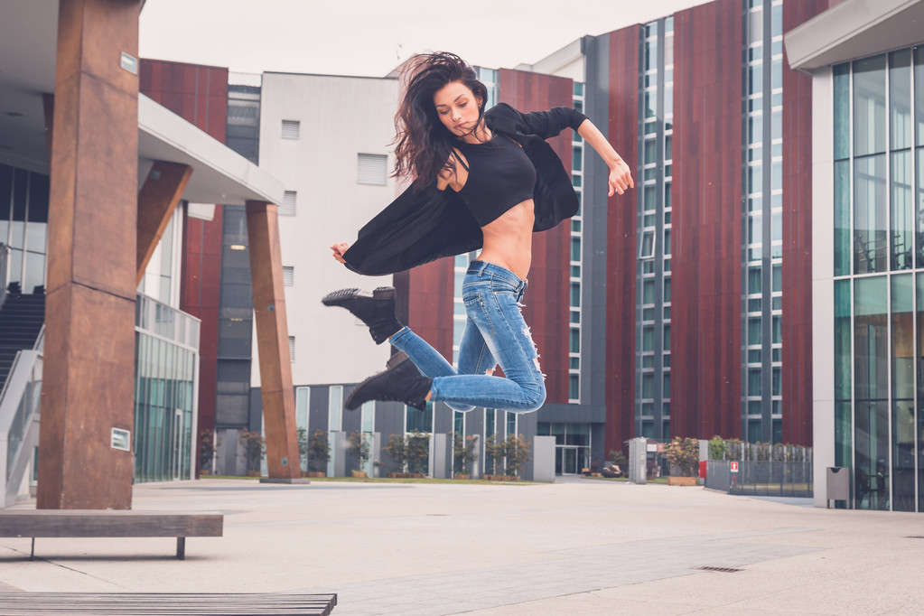 Mooi meisje springen van een bank - Foto, afbeelding