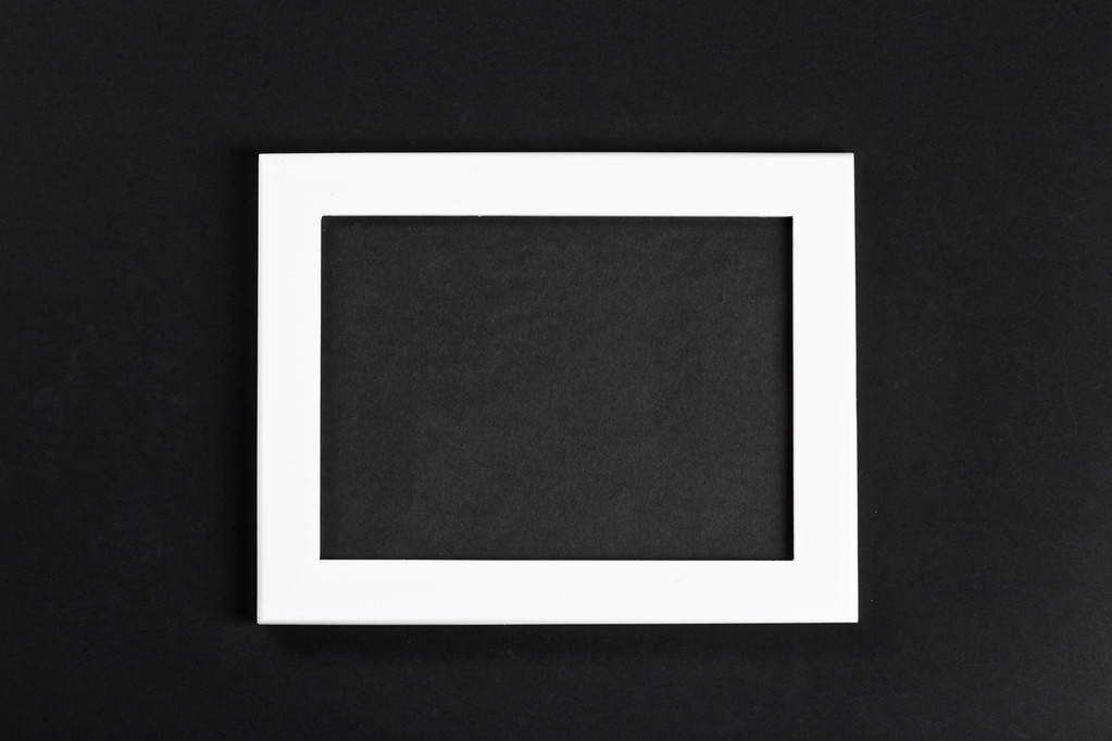 οριζόντια λευκή κορνίζα με μαύρο πεδίο σε μαύρο φόντο, απομονωμένη με πραγματική σκιές - Φωτογραφία, εικόνα