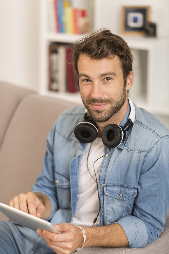 νεαρός άνδρας listenig μουσική με ψηφιακό tablet στο σπίτι - Φωτογραφία, εικόνα