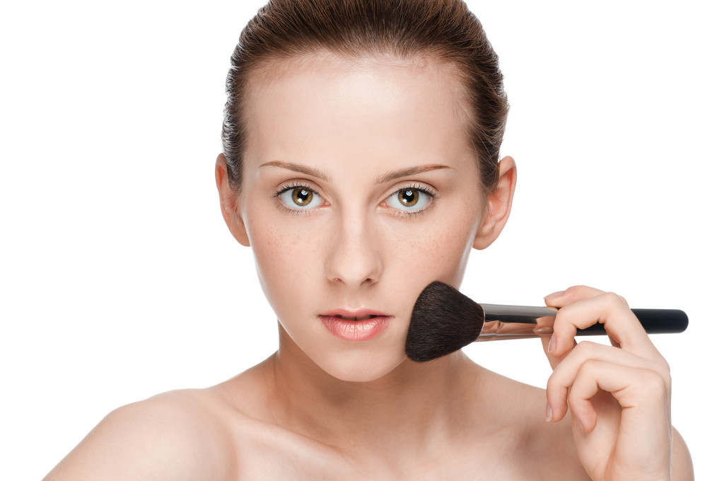 Mulher adulta jovem bonita aplicando escova cosmética
 - Foto, Imagem