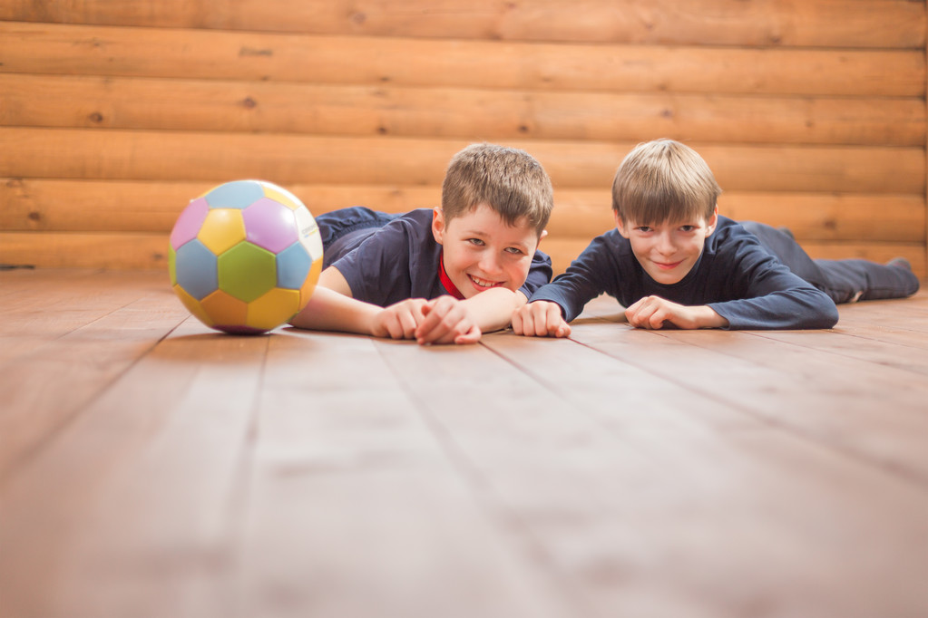 Deux garçons avec une balle couchée sur le sol
 - Photo, image