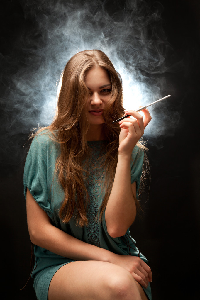 Belle femme aux lèvres pleines assise et fumant
 - Photo, image