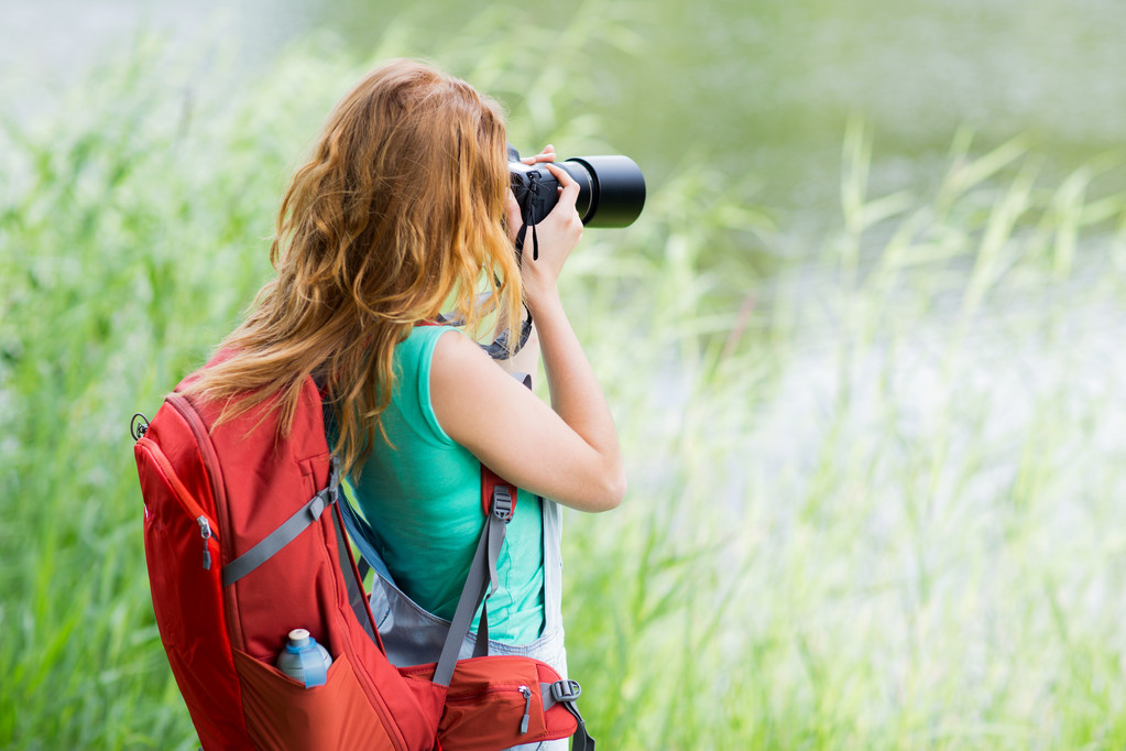 young woman with backpack and camera outdoors - Photo, Image