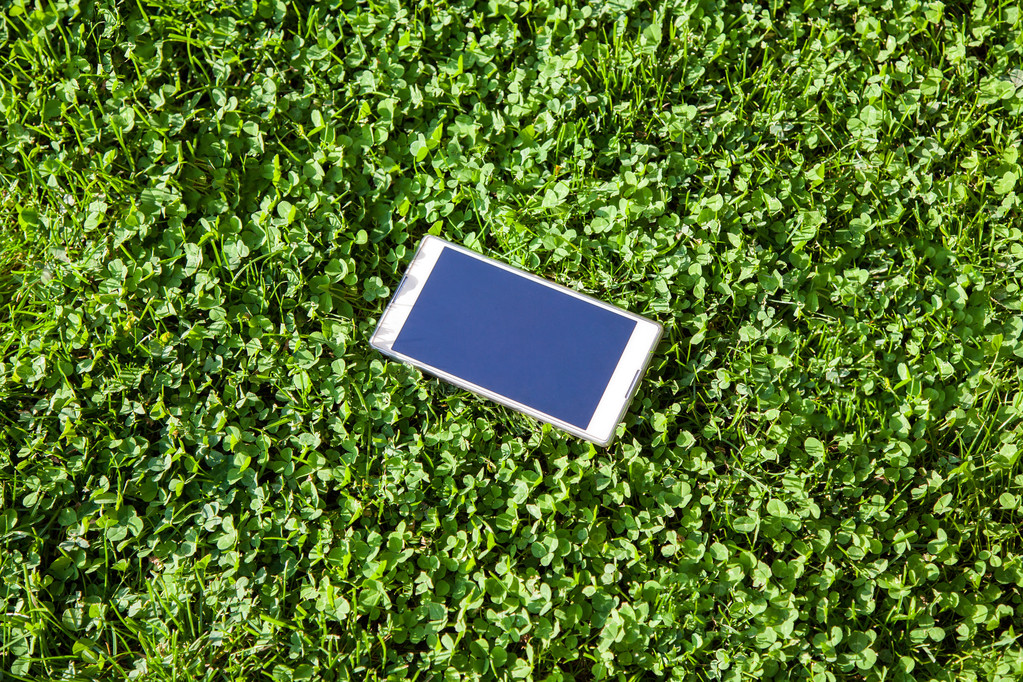 érintőképernyős intelligens telefon a fű a pályán - Fotó, kép