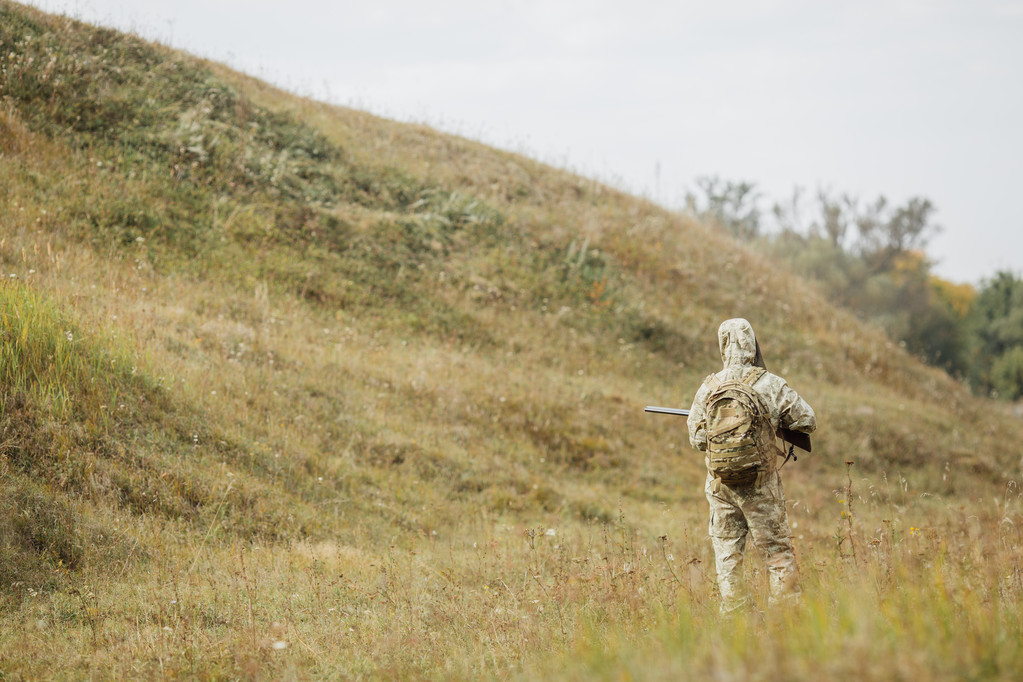 jager in camouflage kleding klaar om te jagen met jachtgeweer - Foto, afbeelding