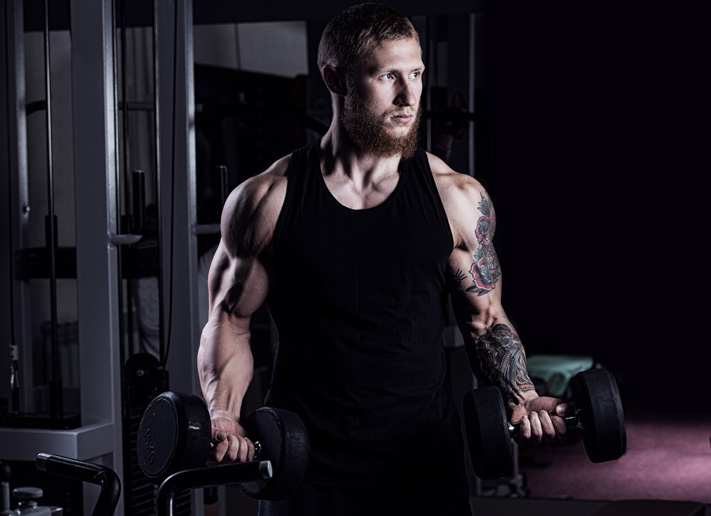 zeer energie-atletische man bodybuilder, uitvoeren van de oefening met stom - Foto, afbeelding