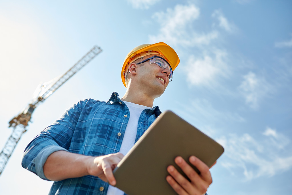 будівельник в хардхаті з планшетним ПК при будівництві
 - Фото, зображення
