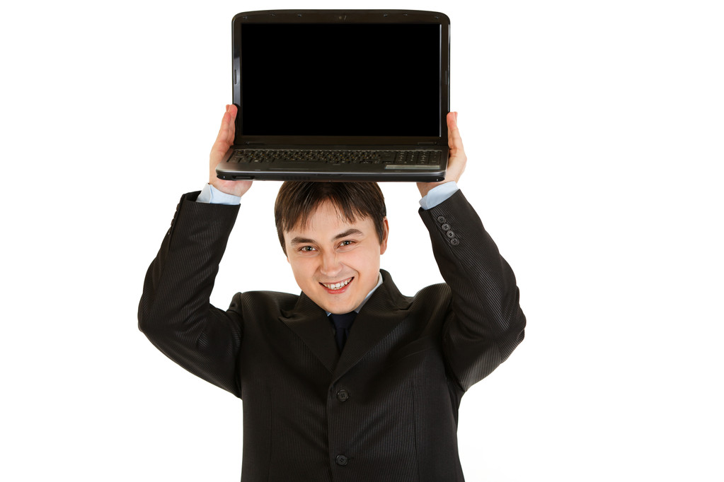 ευχαριστημένος σύγχρονο επιχειρηματία κρατώντας το lap-top με την κενή οθόνη πάνω από το κεφάλι - Φωτογραφία, εικόνα