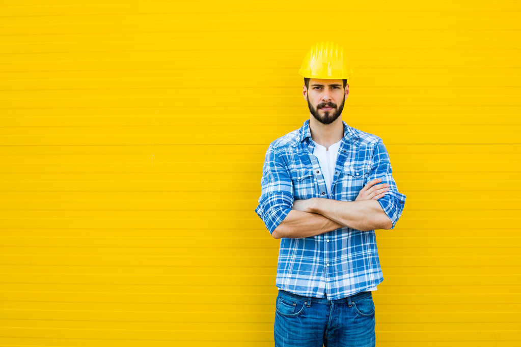 lavoratore adulto con casco su parete gialla
 - Foto, immagini