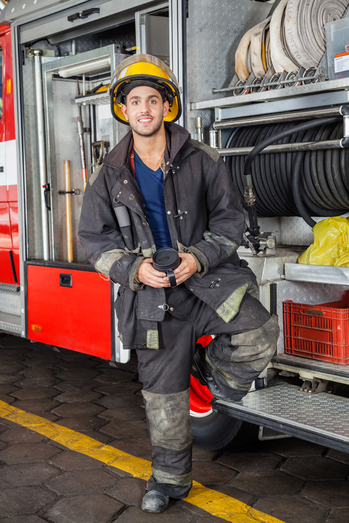 Pompier souriant debout par camion à la caserne de pompiers
 - Photo, image