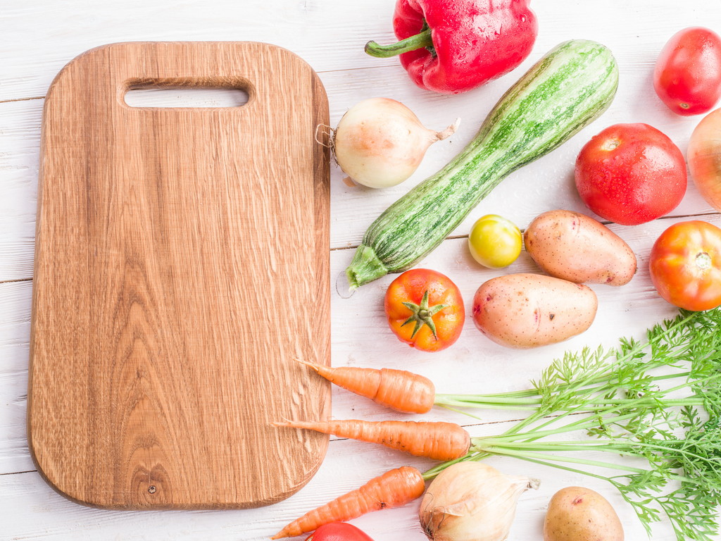 Wooden empty chopping board and vegetables near it. - Photo, Image