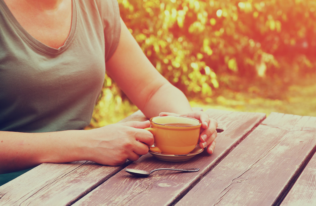 vrouw drinken koffie buiten - Foto, afbeelding