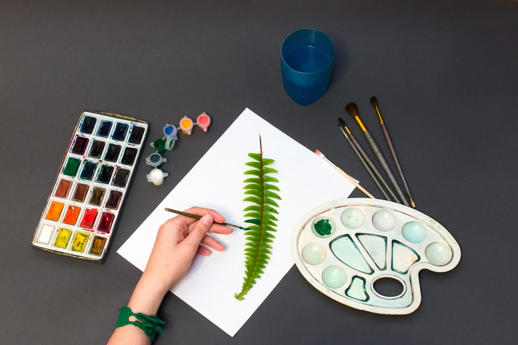 man drawing a fern on a gray background - Photo, Image