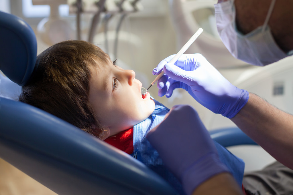 Klein kind, jongen, zittend op een tandarts stoel, met zijn jaarlijkse - Foto, afbeelding