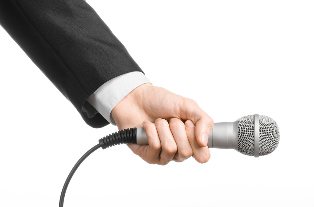 Affaires et discours thème : Homme en costume noir tenant un microphone gris sur un fond blanc isolé en studio
 - Photo, image