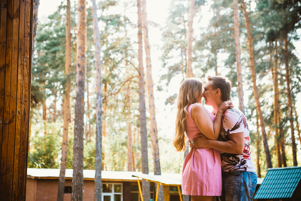 Романтична молода пара цілується на фоні літнього лісу
 - Фото, зображення
