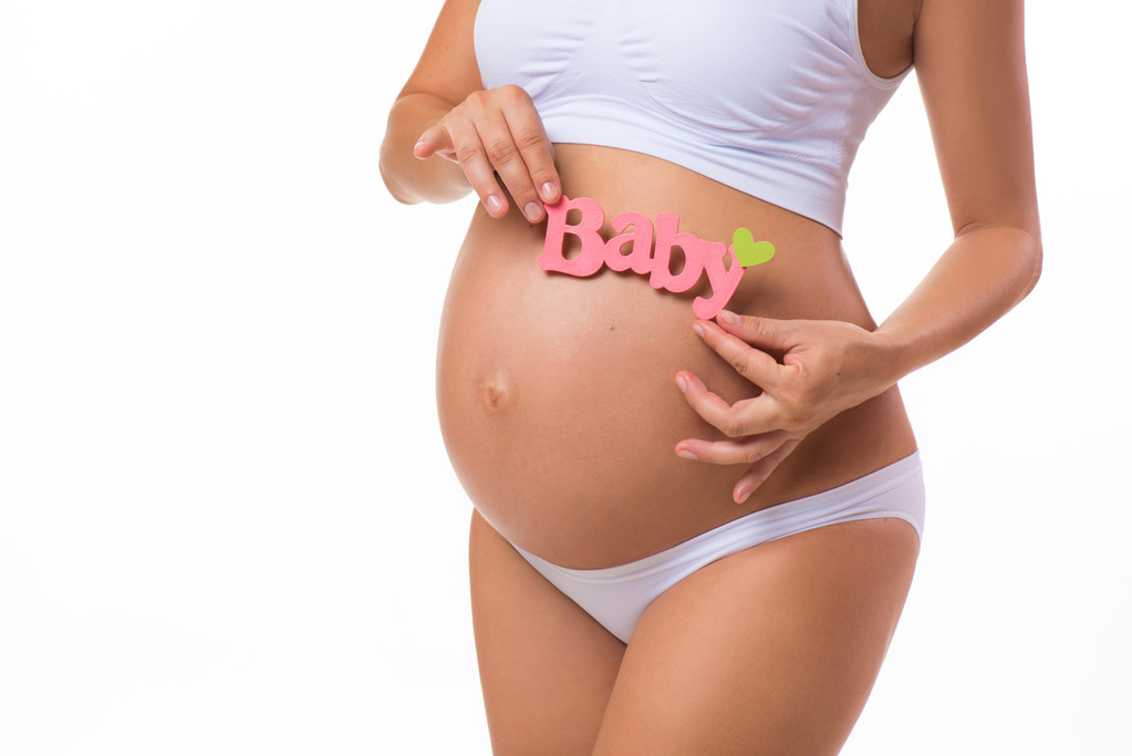 Terhes has a kislány rózsaszín felirattal. Terhes nő várta lánya. Közeli vízszintes elszigetelt fehér background. - Fotó, kép
