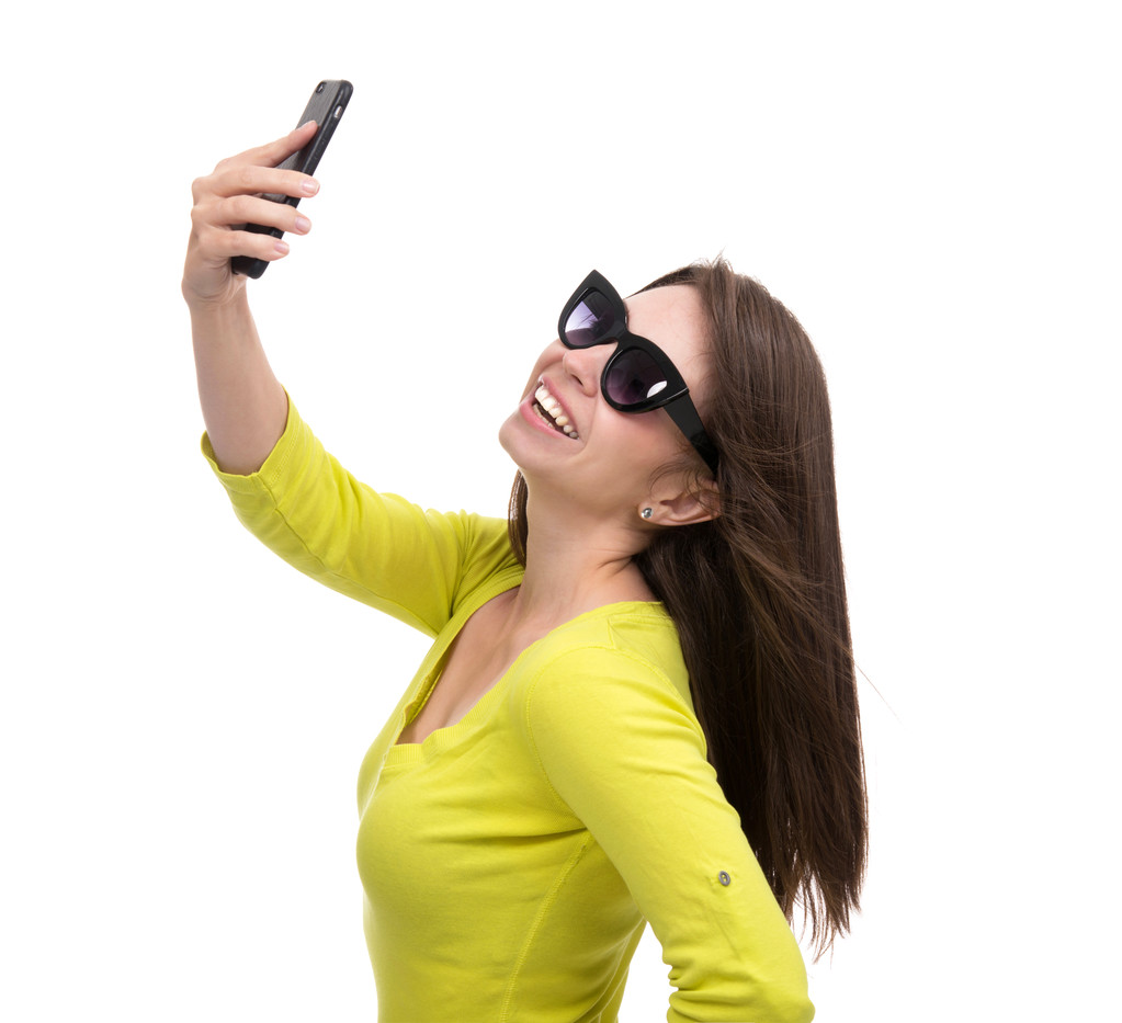 Young pretty girl in sunglasses make self portrait selfie with h - 写真・画像