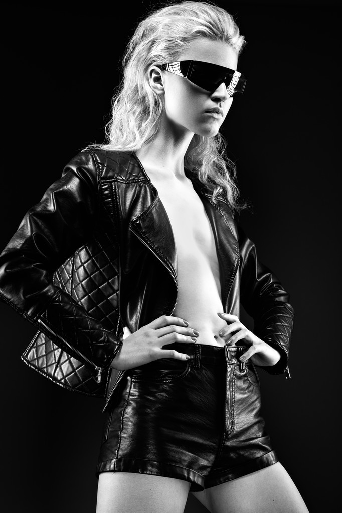Kız modeli moda güneş gözlüğü, çıplak vücut, koyu makyaj, ıslak saç siyah deri giysiler içinde cesur. tarzı rock. Siyah beyaz resim. - Fotoğraf, Görsel