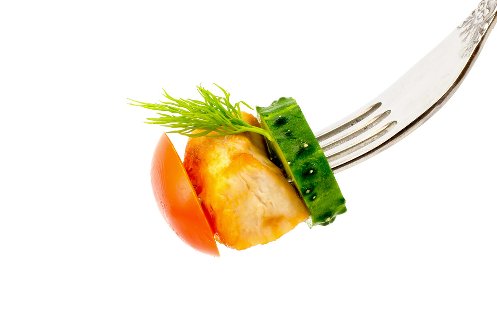 um pedaço de carne frita com legumes closeup em um garfo isolado em um branco
 - Foto, Imagem