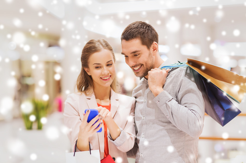 Paar mit Smartphone und Einkaufstaschen in Einkaufszentrum - Foto, Bild