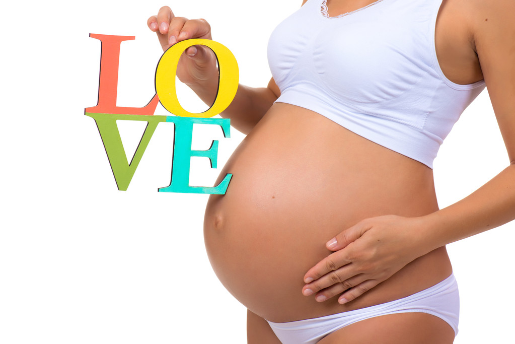 Close-up of a pregnant belly with a sign label Love isolated on  a white background - Photo, Image