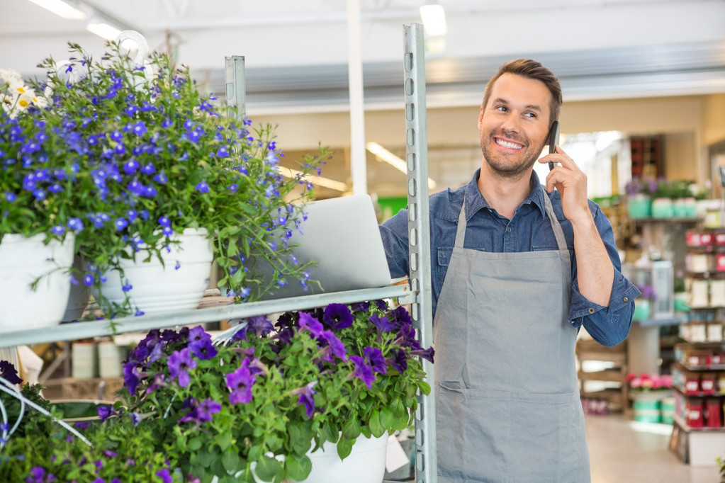 Blumenhändler nimmt Bestellung per Handy im Blumenladen entgegen - Foto, Bild