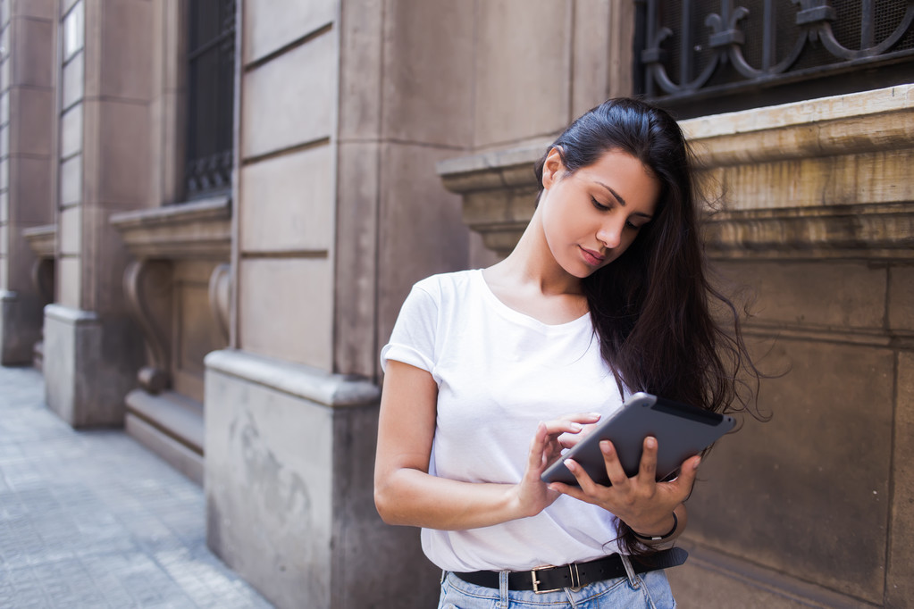 Woman with digital tablet in urban setting - Fotoğraf, Görsel