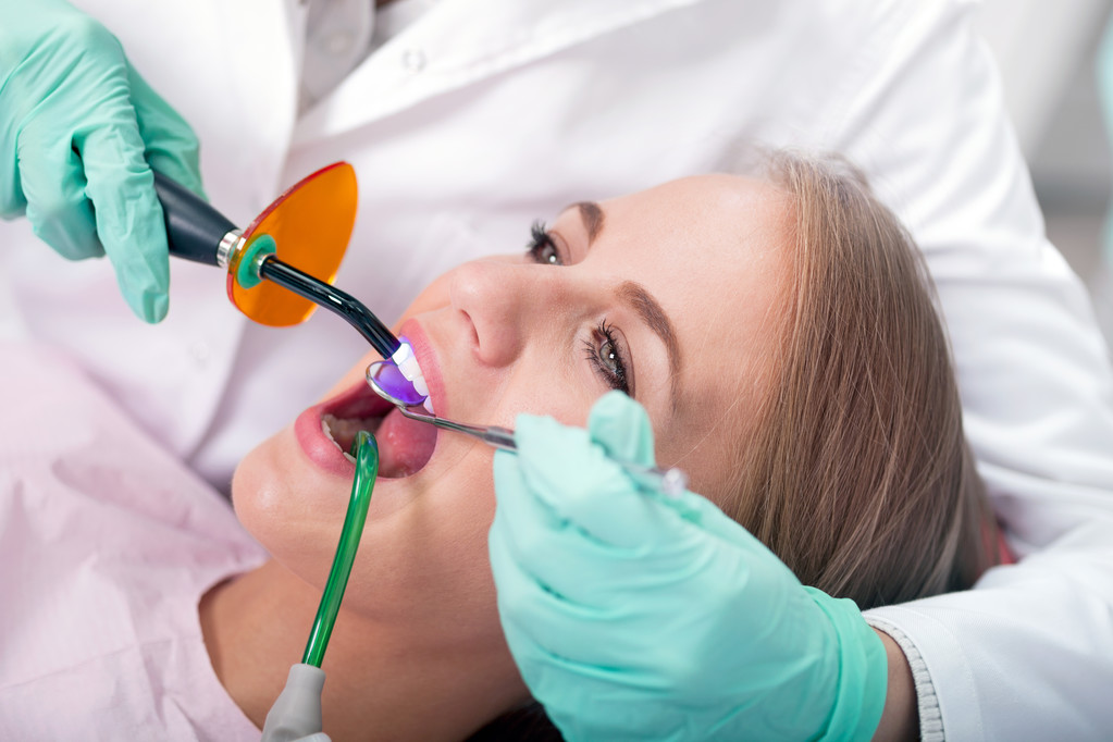 dentist is treating teeth of the female patient - Photo, Image