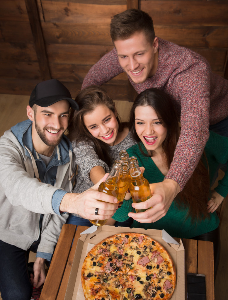 glückliche Freunde ruhen sich mit Alkoholgetränken in der Pizzeria aus - Foto, Bild