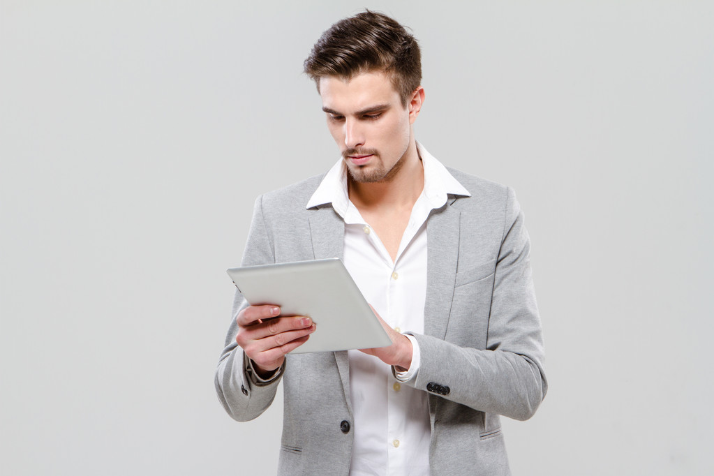 Concentrated young businessman using tablet - Photo, Image