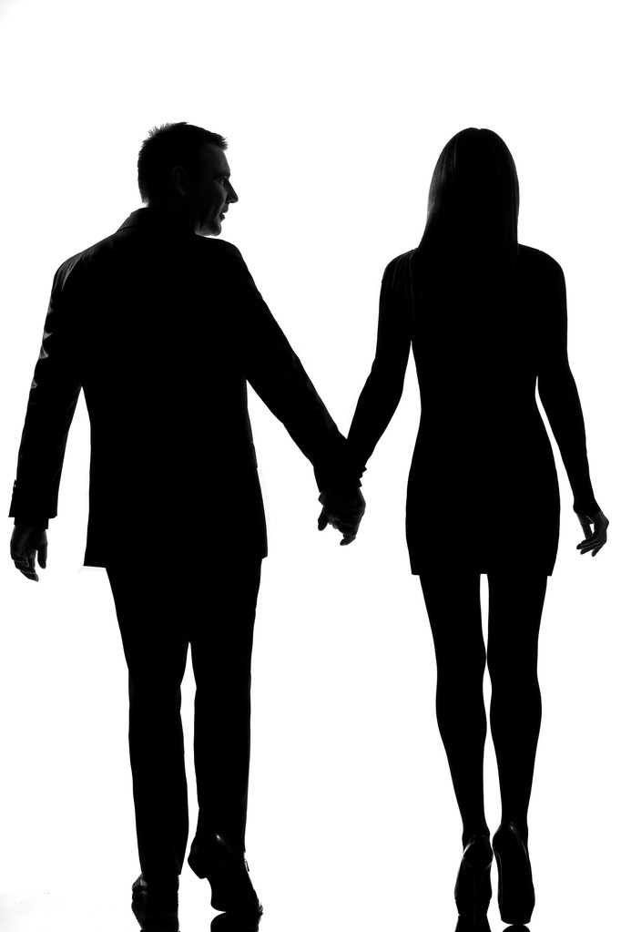 Achteraanzicht een liefhebbers paar man en vrouw lopen hand in hand - Foto, afbeelding