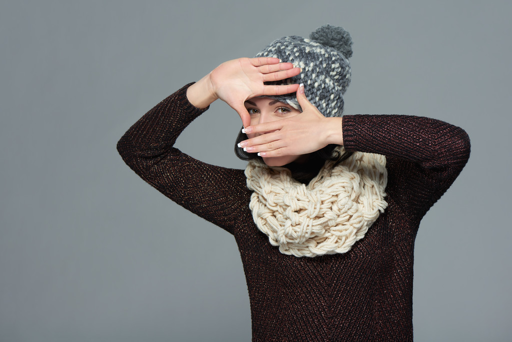 Frau in Winterkleidung bastelt mit ihren Händen einen Rahmen - Foto, Bild