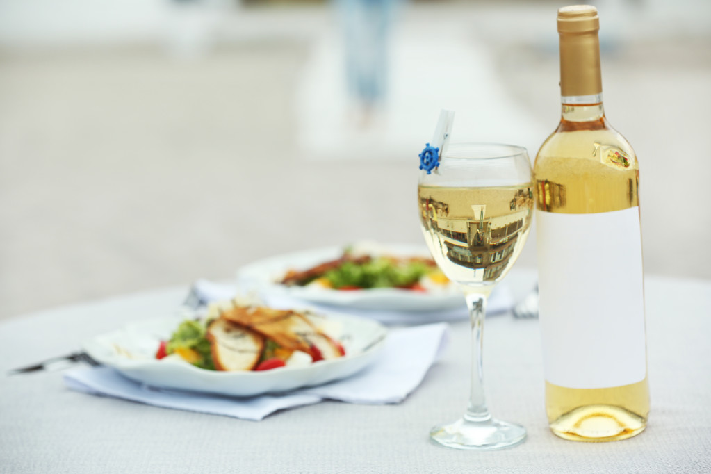 Bouteille de vin de luxe avec salade savoureuse sur table blanche servie
 - Photo, image