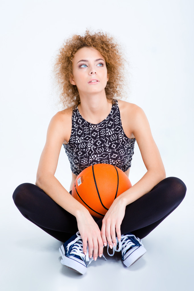 Жінка сидить на підлозі з баскетбольним м'ячем
 - Фото, зображення