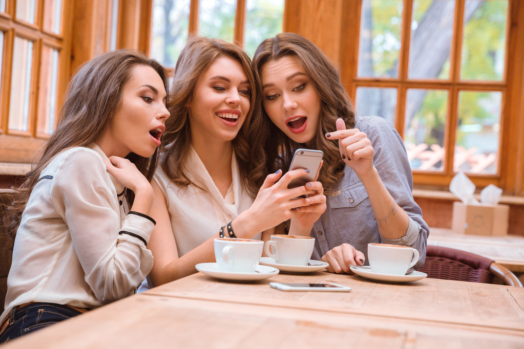 Alegre tres mujeres usando teléfono inteligente
 - Foto, imagen