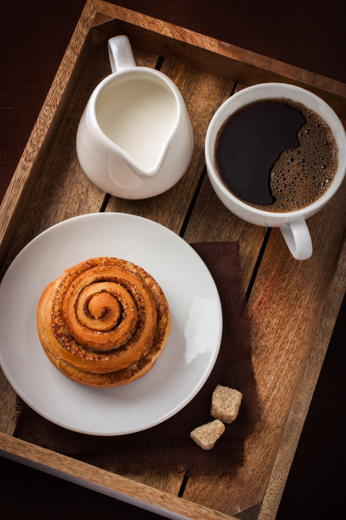 cinnamon roll,  cup of coffee and cream  on wooden tray - Photo, Image