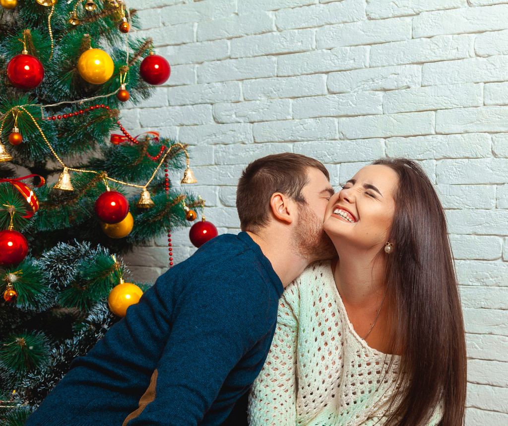 хлопець цілує дівчину під ялинкою на Різдво
 - Фото, зображення