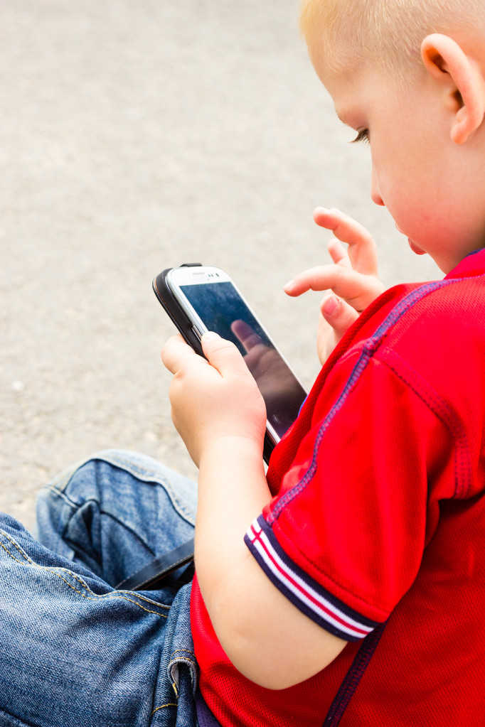 μικρό αγόρι παιδί που παίζει τα παιχνίδια στο κινητό τηλέφωνο εξωτερική - Φωτογραφία, εικόνα