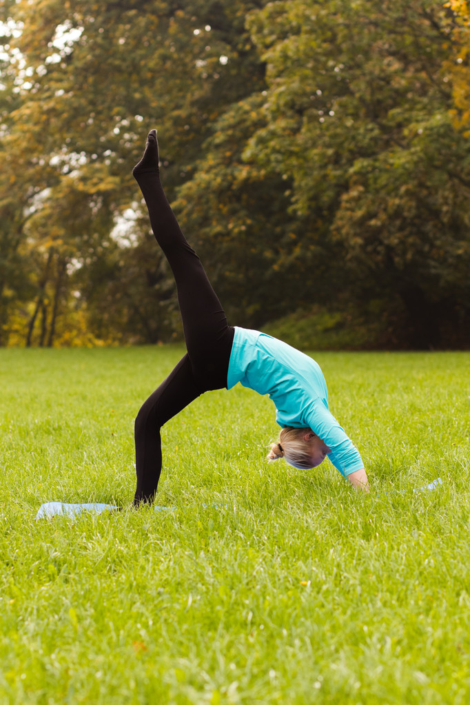 Woman practicing yoga in park - Photo, Image
