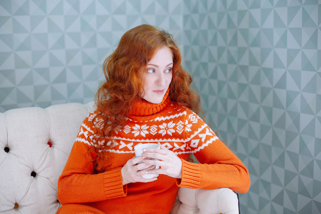 Затишний портрет жінки в теплому светрі на ліжку з чашкою т
 - Фото, зображення