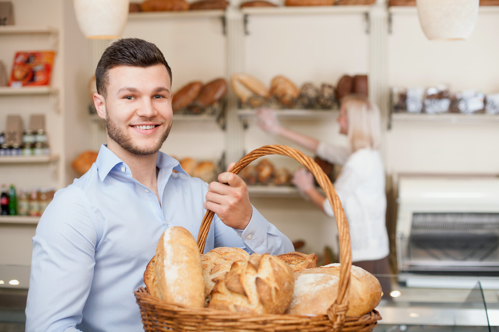 Attractive young guy is purchasing fresh bread - Photo, Image