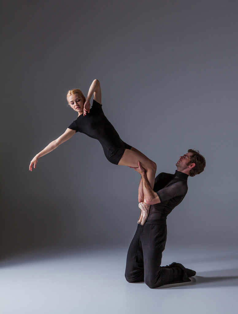 twee jonge modern balletdansers op grijze studio achtergrond - Foto, afbeelding